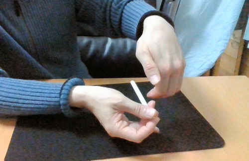 右手の中指を使って、タバコを右手の内側に移動させる