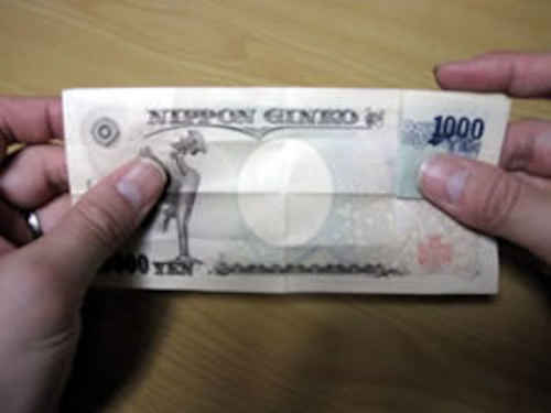 一万円札を広げる
