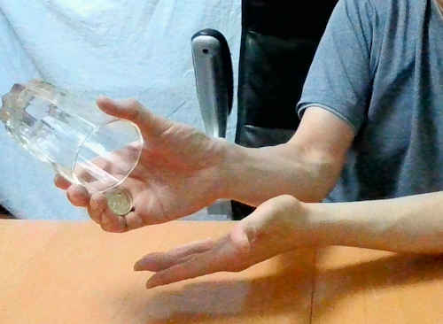 右手の薬指と中指でコインを保持する
