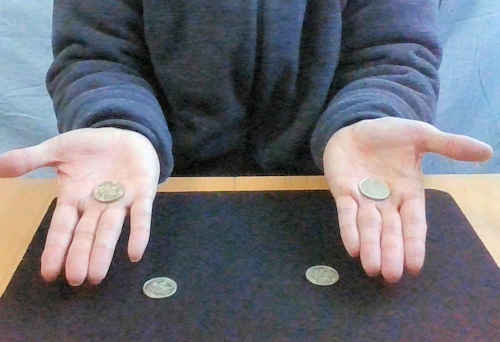 左右の手に１枚ずつコインをおきます