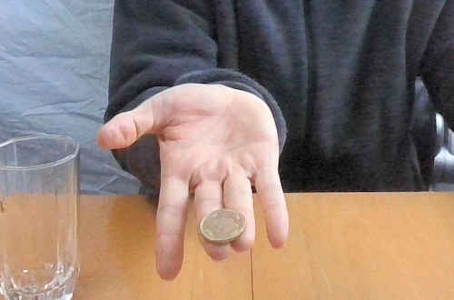 右手の中指と薬指の先にコインを置きます