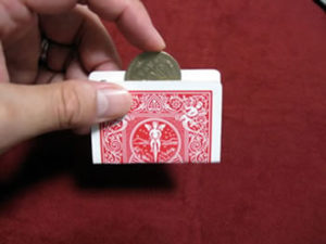 カードの小さな穴に500円玉を貫通させる