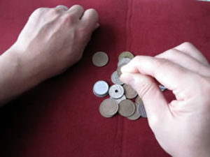 右手でコインを持っているような手の形をつくる
