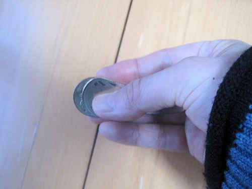 のびる500円玉の上に通常の500円玉をかさねる