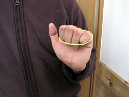 輪ゴムを４本の指の爪の付け根にかかるようにひっかけて手を握る
