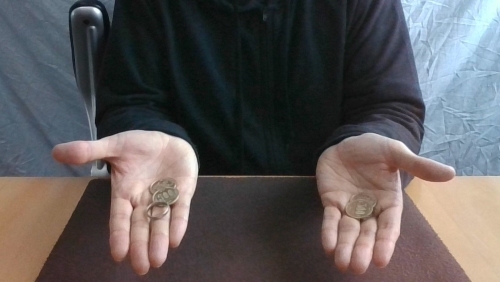 右手はコインと指輪を持っている。