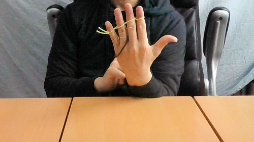 手を広げると輪ゴムは、薬指と小指に移動します。