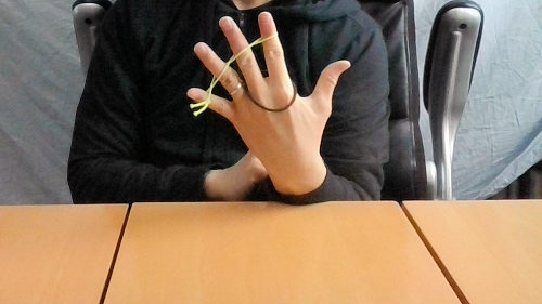 手をひらくと、輪ゴムは人差し指と中指に移動します