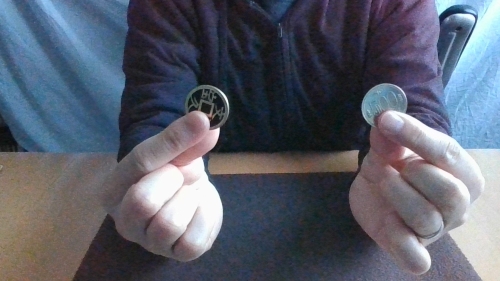 左手に500円玉、右手に文永久宝のコイン
