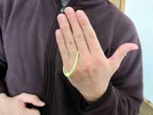 左手を開くと輪ゴムが中指と小指に移動している。