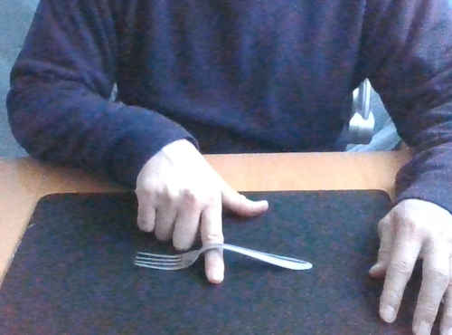 フォークをテーブルに置き、右手の人差し指を曲がった付け根に入れます