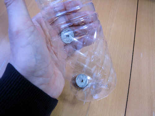 ペットボトルを立てると、キャップの裏に隠していたコインが落ちてきます