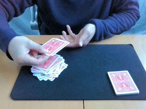 マジシャンは手に持っていた全てのカードをテーブルのカードに重ねます