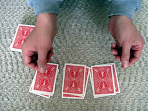 左手に持っている全てのカードを３つの山に分けてテーブルに置いた
