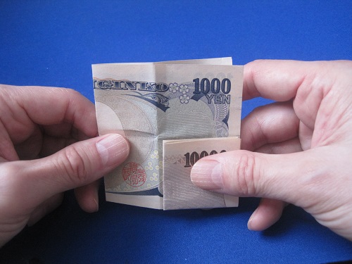 千円札を左から右に半分に折ります
