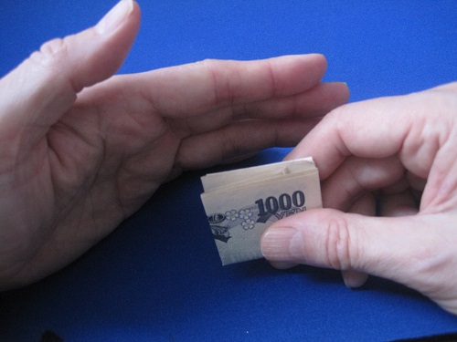 お札をひっくり返して、一万円札を表側に見せます