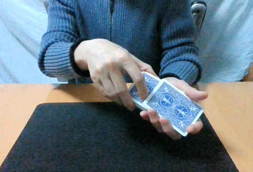 左手の親指と中指で数枚カードをとる