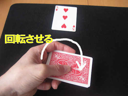 マジシャンは手元のカードを回転させて向きを反対にする