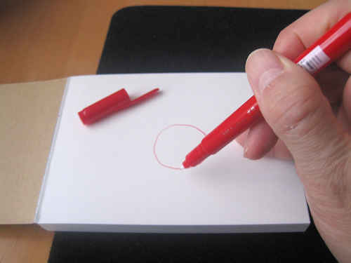 メモ帳に、赤のペンで〇を描く