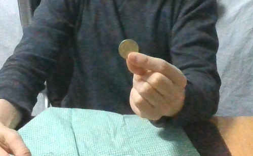 左手に持ったコインを見せます