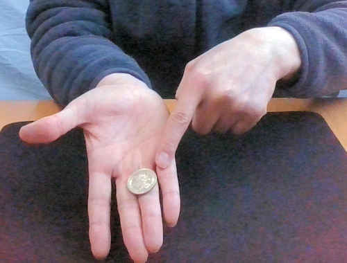 右手の薬指の付け根にコインをおく