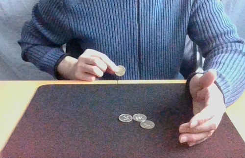 テーブルの下にある右手を見せると、コインがテーブルを貫通した