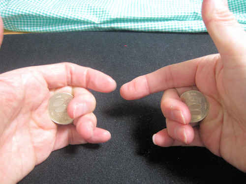 中指と薬指を曲げてコインを保持します