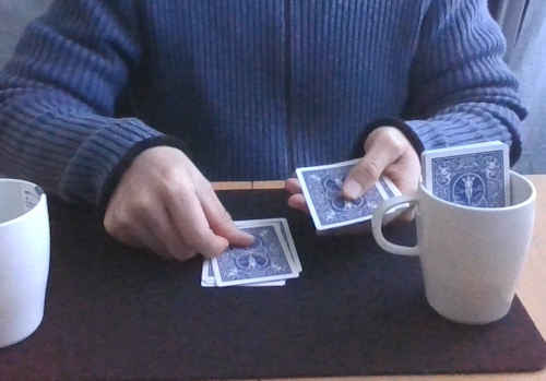 カード２枚を裏向きにして、テーブルのトランプに重ねる
