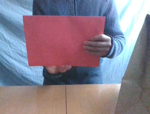 赤色の封筒を横にして３回まわします