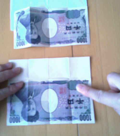 千円札の右上はしと白紙の右下はしを貼り合わせた