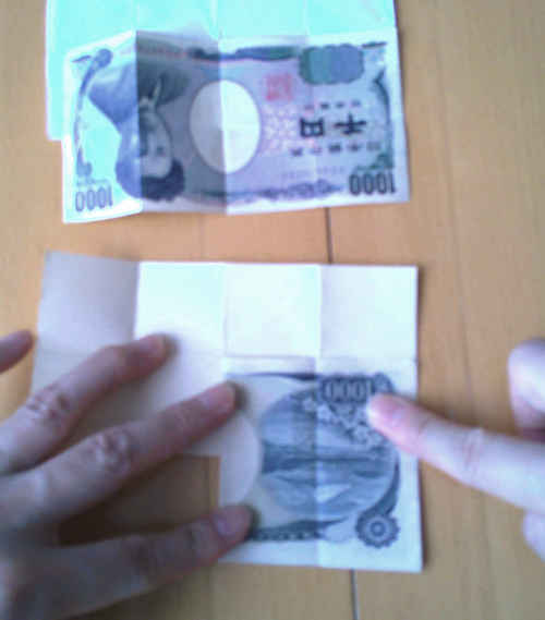千円札を左から右に半分に折りたたむ