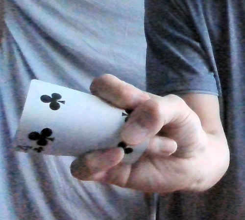 人差し指と小指でカードを押さえている