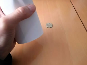 紙で包んだコップをコインの上におく
