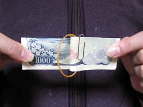 千円札を両手で横の引っ張る