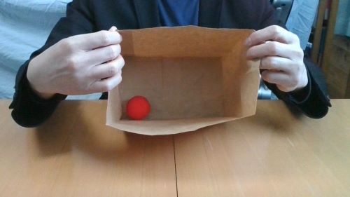 紙袋に赤いボールが入ったように見せます。