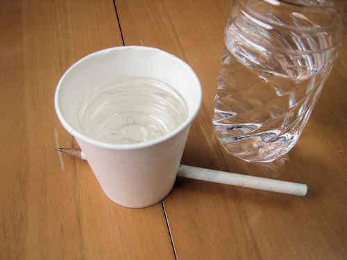 水を、紙コップの中の受け皿に注ぎます