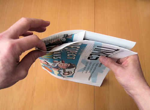 新聞紙の本体の角だけが、内側に折り込まれている